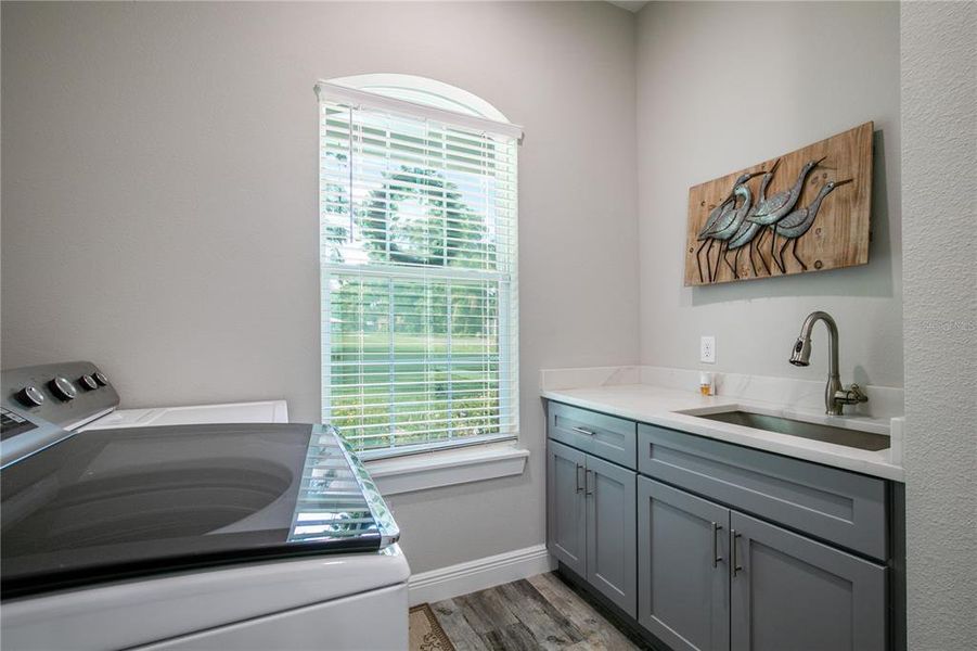 Large indoor laundry room with vanity. Washer and dryer do not convey.