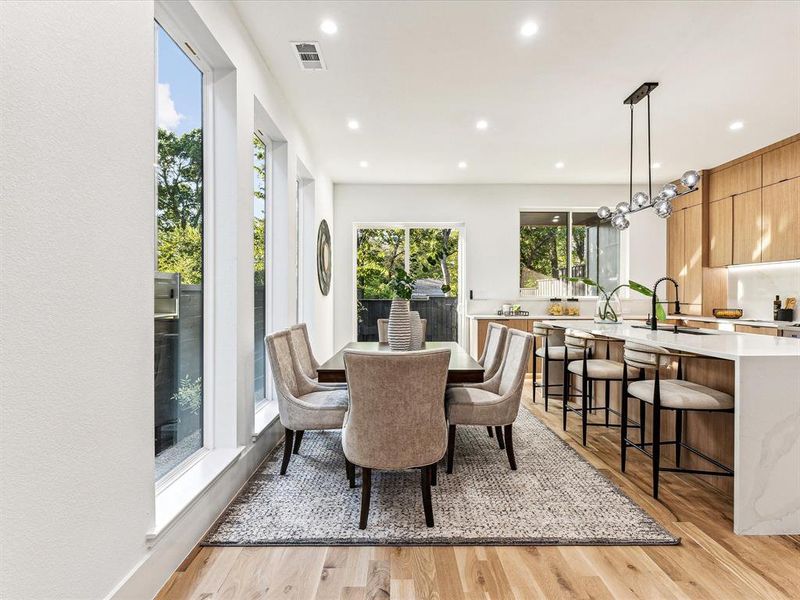 Dining room featuring an inviting chandelier, light wood-type flooring, and sink