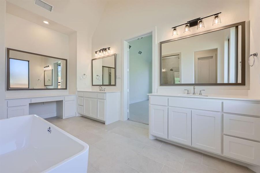 Bathroom with vanity, shower with separate bathtub, vaulted ceiling, and tile patterned flooring