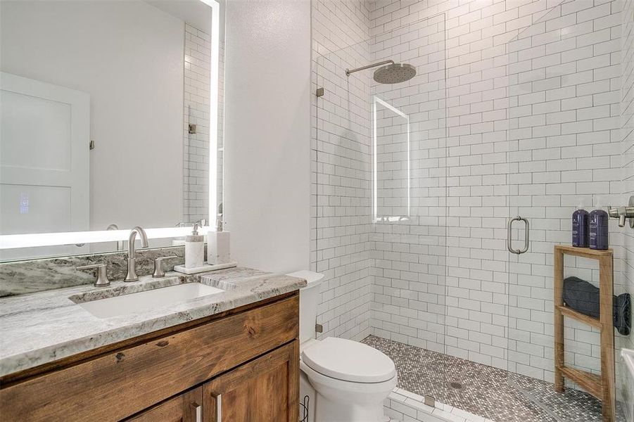 Spacious secondary bathroom with elegant fixtures, a large vanity, and plenty of storage.