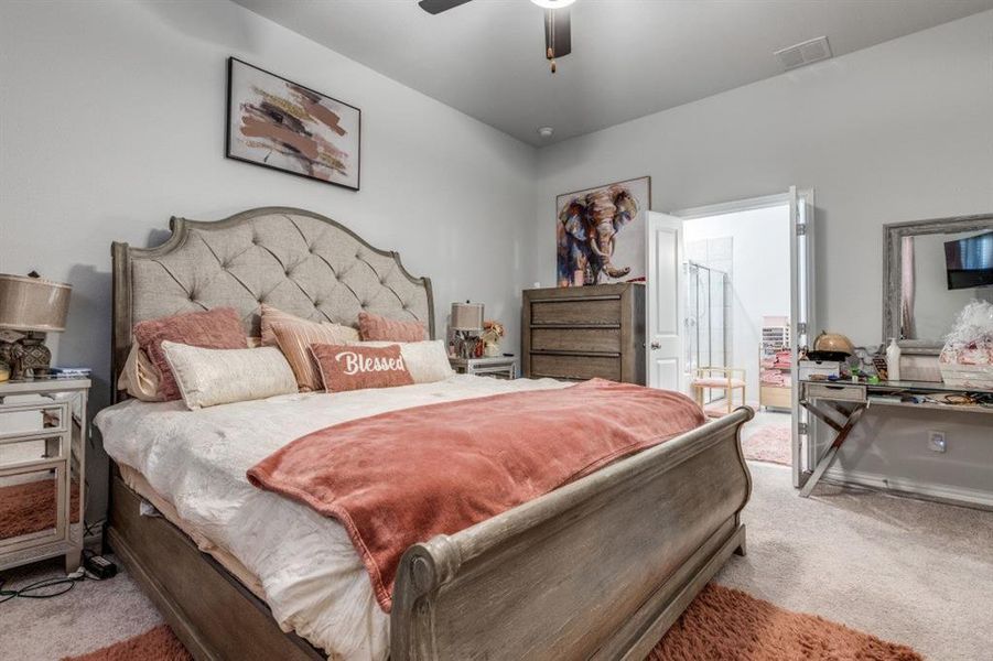 Bedroom with ceiling fan and light colored carpet