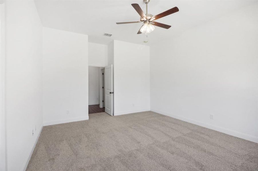 Carpeted spare room featuring ceiling fan