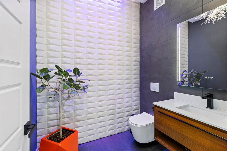 A pop of color adds a touch of whimsy to the guest powder bath with floating vanity and toilet.