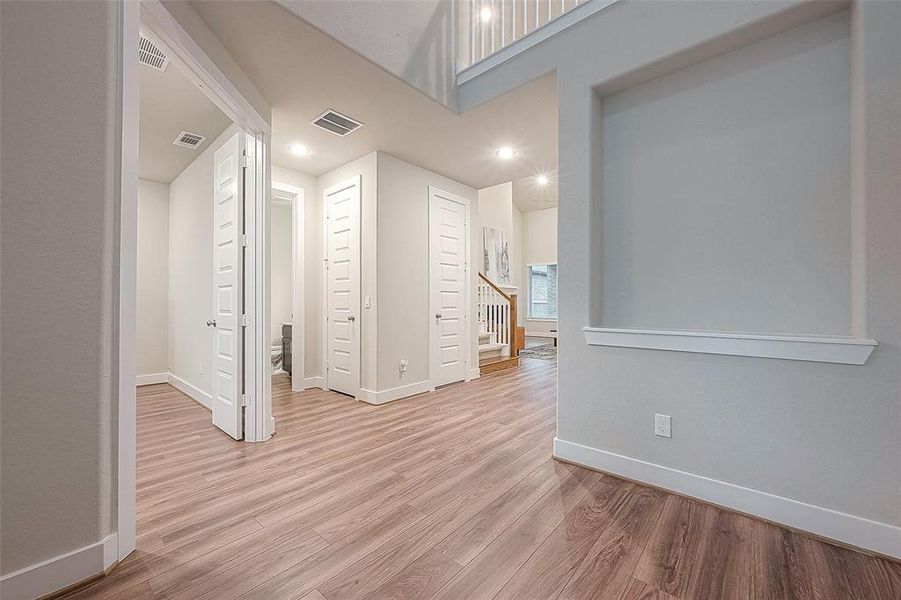 Enter through the 8' wood door to an inviting, two-story entry with luxury vinyl flooring that looks like wood.