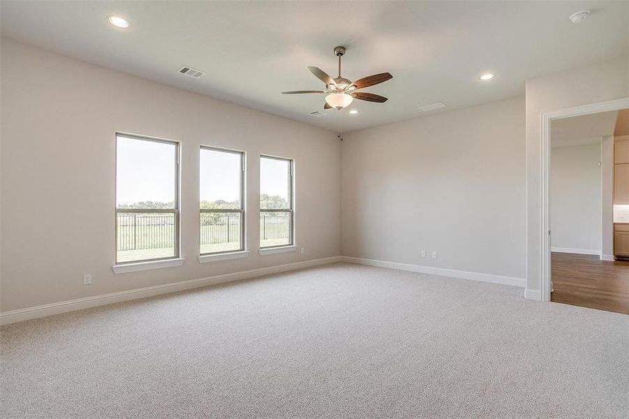 Carpeted spare room with ceiling fan