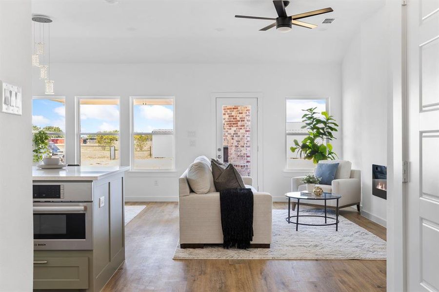 Living room with light hardwood / wood-style floors and ceiling fan