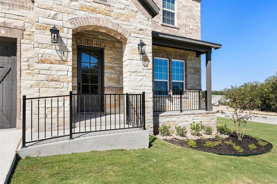 An long sidewalk, lined with black-iron railing, leads you to the front door. Enjoy a quaint front patio with continued black-iron railing.