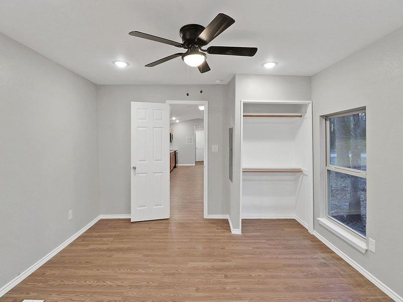 Unfurnished bedroom featuring ceiling fan, a closet, and light hardwood / wood-style flooring