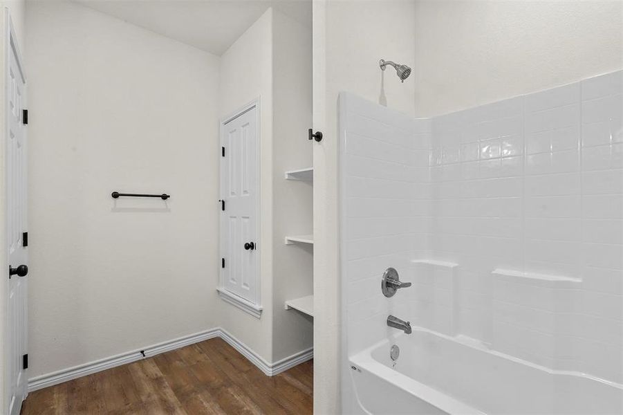 Bathroom featuring hardwood / wood-style flooring and shower / bathing tub combination