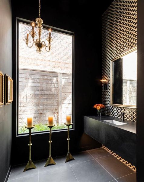 Barden envisioned a more elegant and extravagant spec, and imagined a dramatic powder room with antique Venetian chandelier, Kelly Wearstler sconces, and a wall of hand-cut onyx.