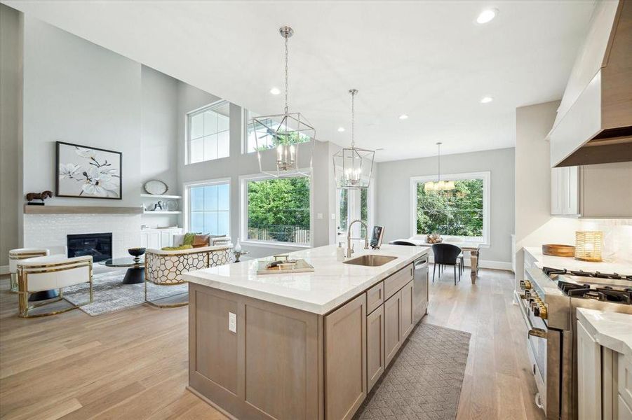This is a modern, open-concept living space with high ceilings, natural light, a cozy fireplace, and a spacious kitchen with a central island, perfect for entertaining and comfortable living.