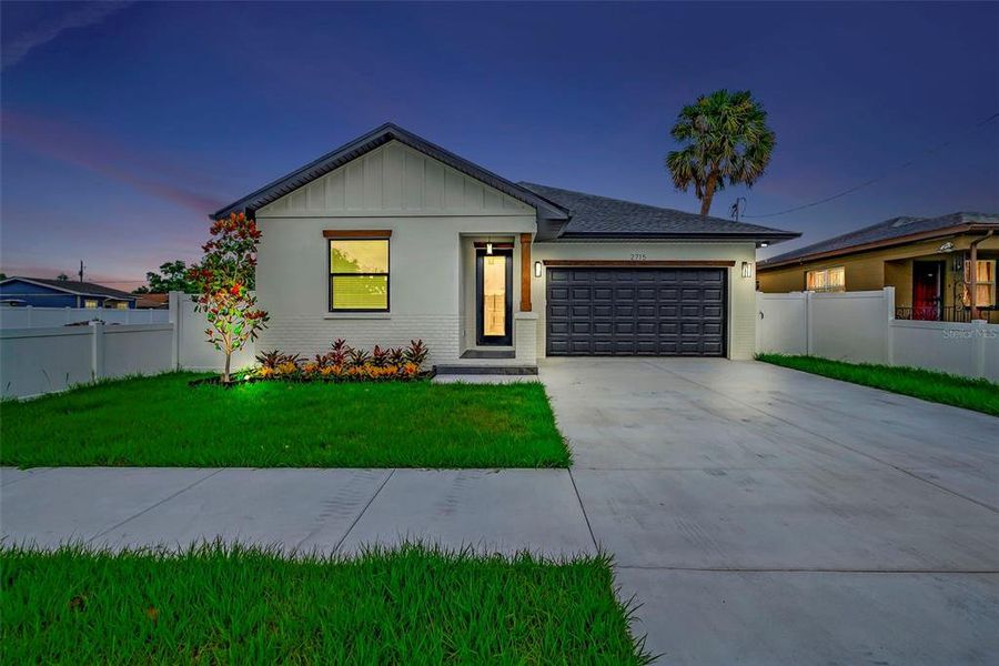 Beautifully landscaped home with a lush yard, inviting front entrance, and a sleek garage door - the perfect blend of curb appeal and functionality.