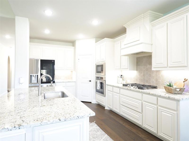 Kitchen featuring dark hardwood / wood-style flooring, stainless steel appliances, white cabinets, and sink