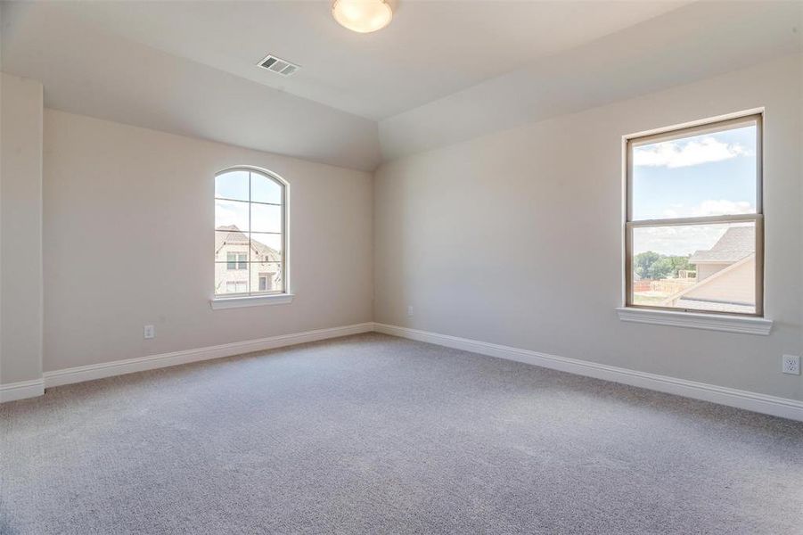 Empty room with a healthy amount of sunlight and carpet