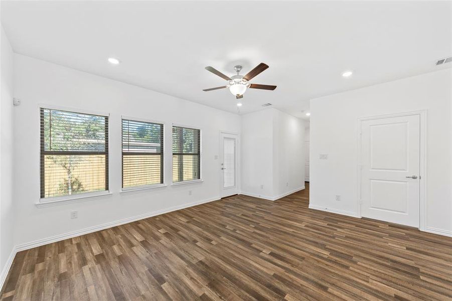 Spare room featuring dark wood-type flooring and ceiling fan