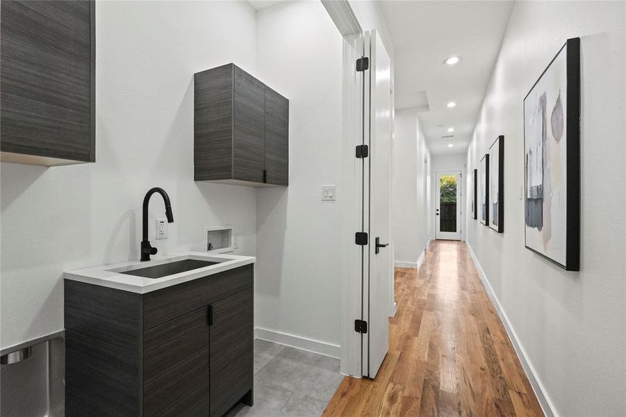 Corridor with light hardwood / wood-style flooring and sink