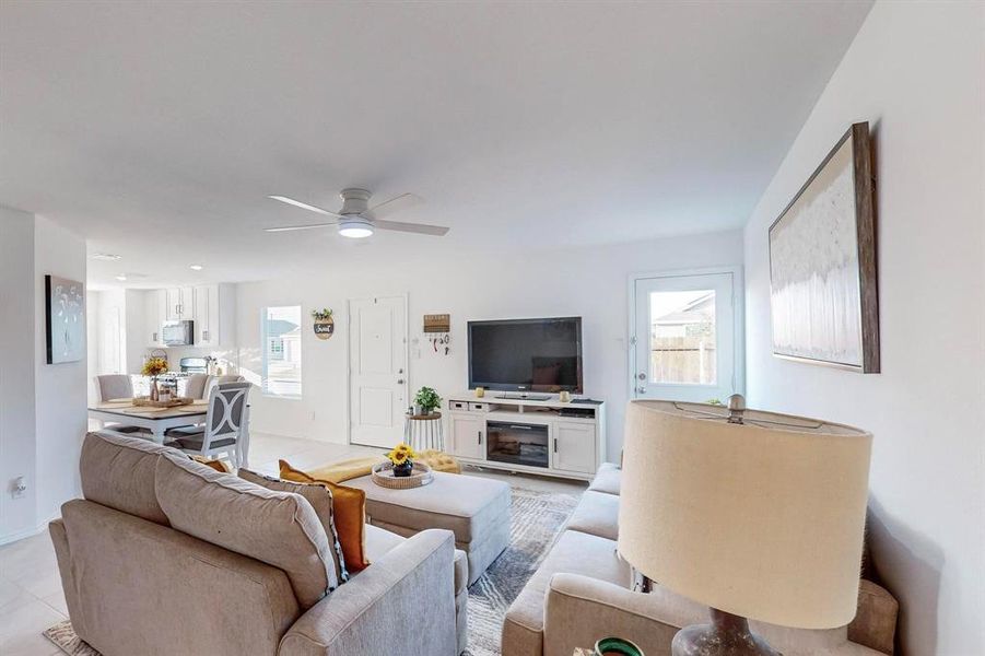 Tiled living room with ceiling fan and a healthy amount of sunlight