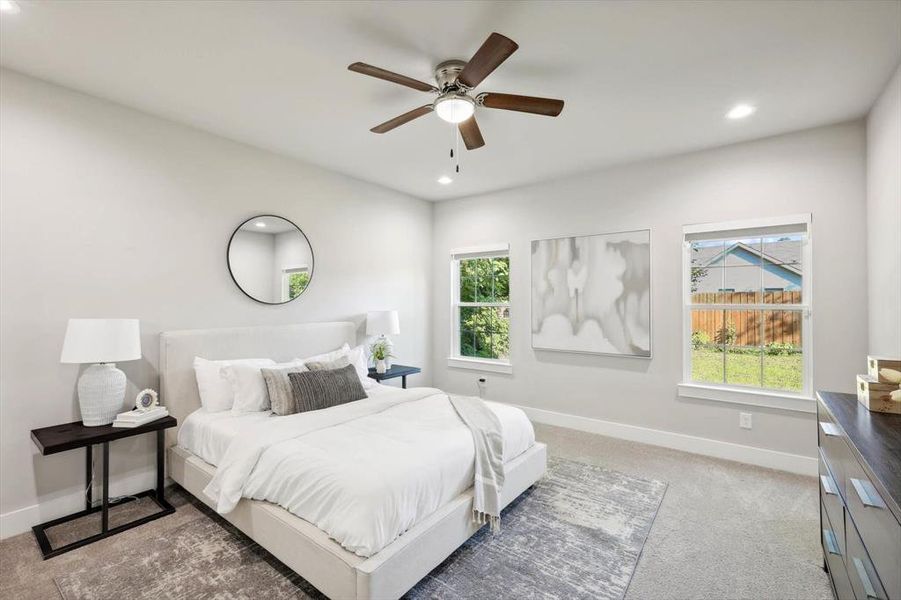 Primary Bedroom featuring ceiling fan and two large windows