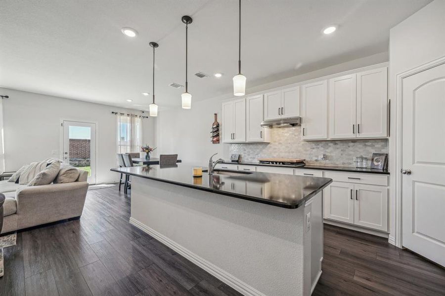 Kitchen featuring white cabinets, dark hardwood / wood-style floors, sink, and hanging light fixtures