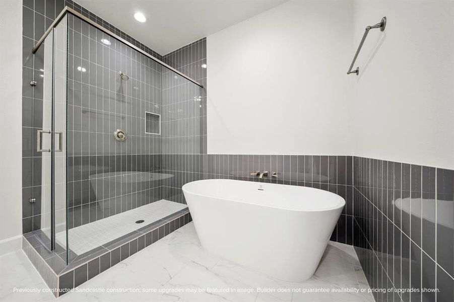 Indulge in the luxurious primary bathroom with a spacious soaking tub and a shower complete with a handy shampoo nook.