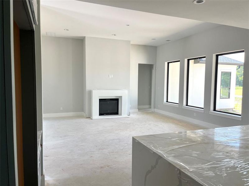 Family room with a gas log fireplace and a cast stone surround.