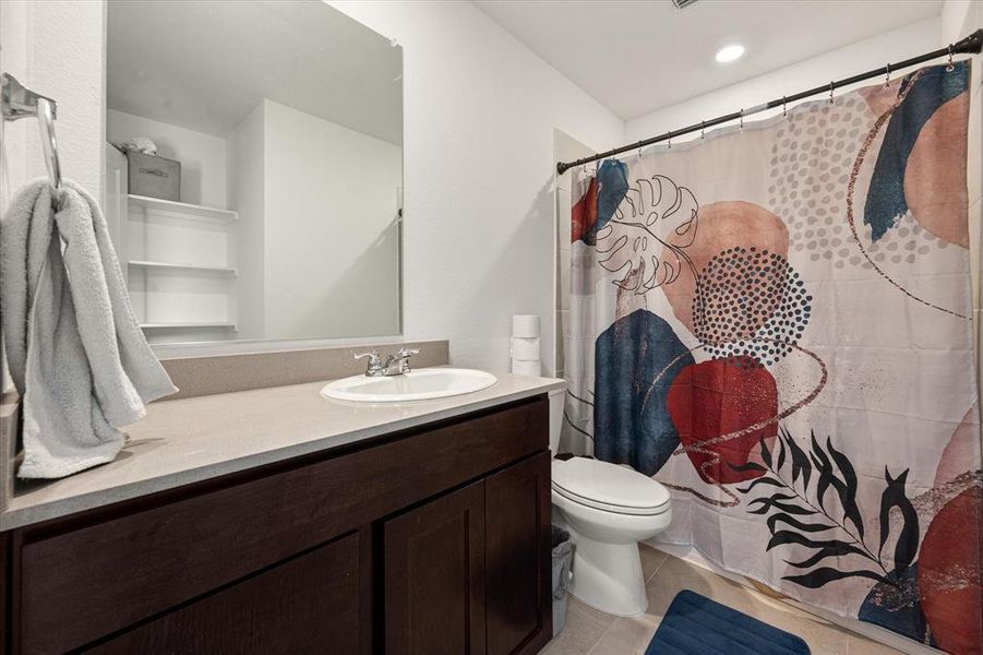 Bathroom with vanity, toilet, and tile patterned floors