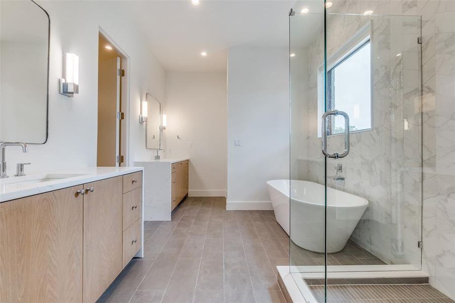 Primary bath offers dual vanities, soaking tub and walk-in shower.