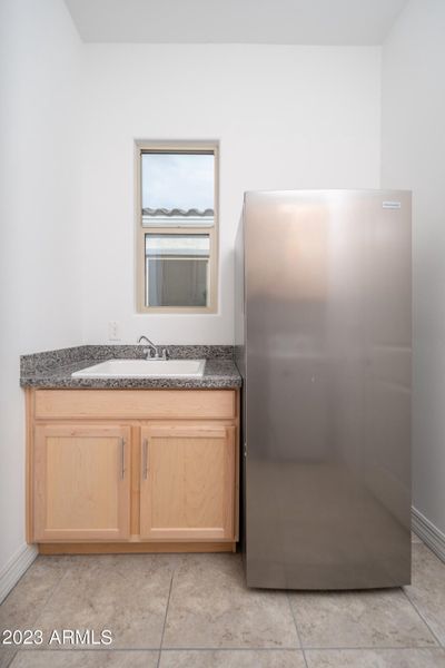 Cabinets, sink, freezer at laundry room