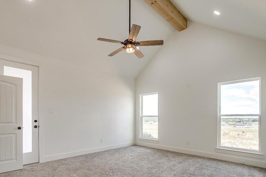 Spare room featuring light carpet, high vaulted ceiling, beam ceiling, and ceiling fan