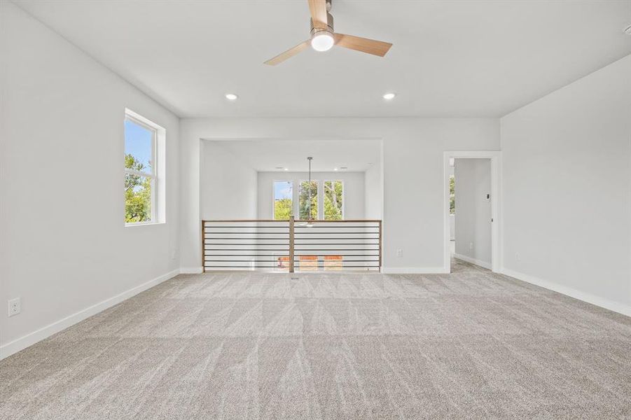 Carpeted spare room featuring ceiling fan