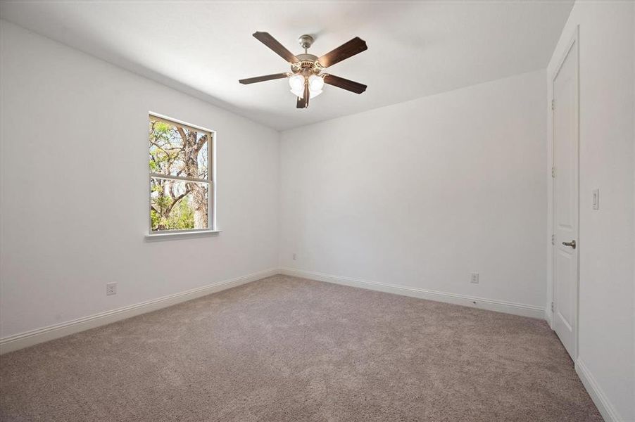 Empty room with ceiling fan and carpet