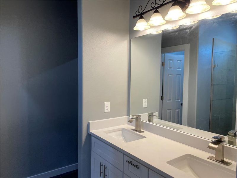 Bathroom featuring vanity and a tile shower