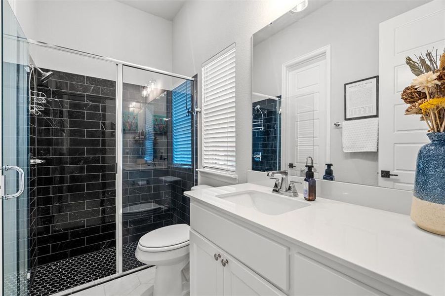 Bathroom featuring walk in shower, tile flooring, oversized vanity, and toilet