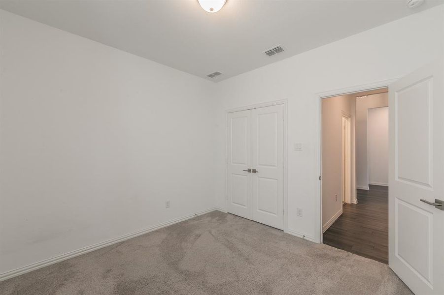 Unfurnished bedroom featuring carpet and a closet