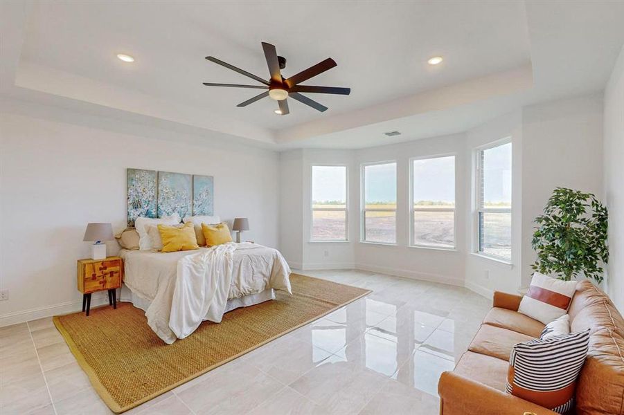 Tiled bedroom with a tray ceiling and ceiling fan