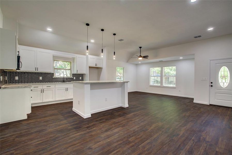 Kitchen featuring dark hardwood / wood-style floors, ceiling fan, white cabinets, and tasteful backsplash