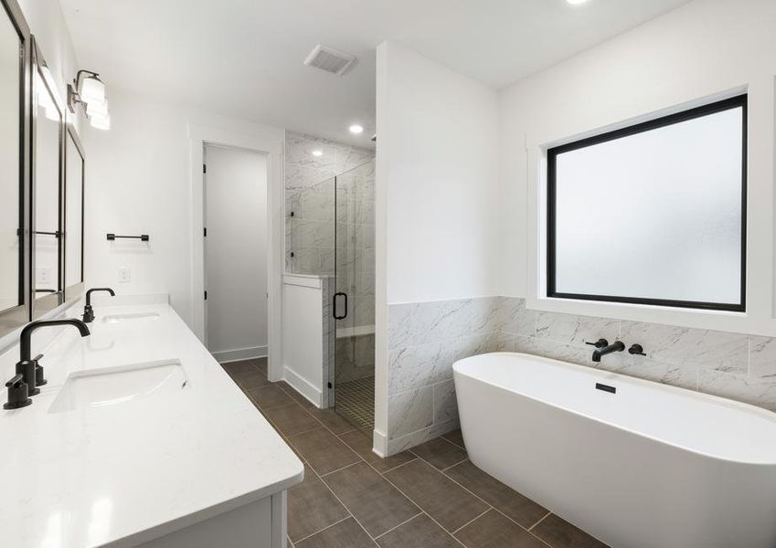 The gorgeous master bathroom has a large glass, walk-in shower and tub.