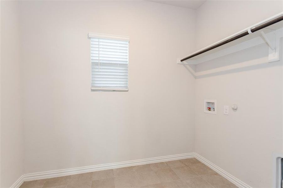 Washroom featuring gas dryer hookup, hookup for a washing machine, and light tile patterned floors