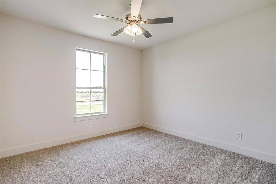 Carpeted empty room with ceiling fan