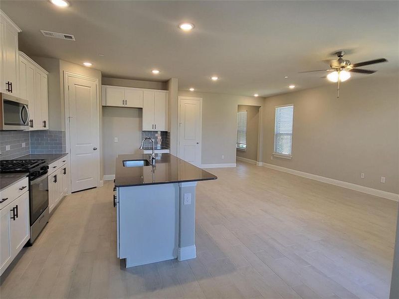 Kitchen featuring stainless steel appliances, light hardwood / wood-style floors, white cabinetry, and sink