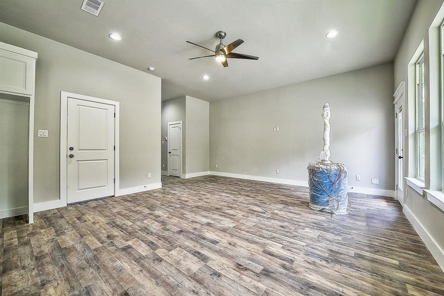 Unfurnished bedroom with ceiling fan and dark wood-type flooring