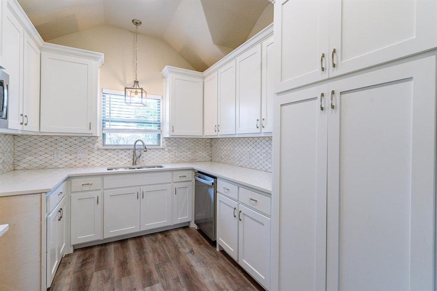 Kitchen with dishwasher, white cabinetry, pendant lighting, and lofted ceiling SELLER to install SS RANGE