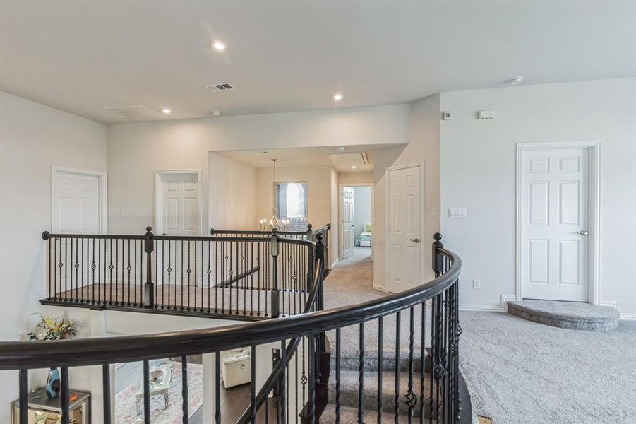 Hallway featuring a notable chandelier and carpet floors