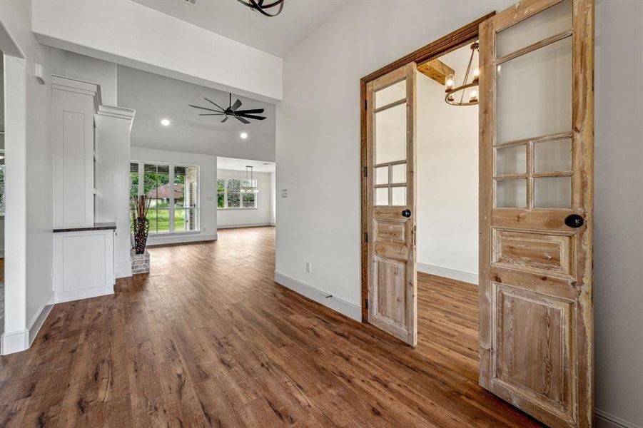 Hall with hardwood / wood-style flooring and a notable chandelier