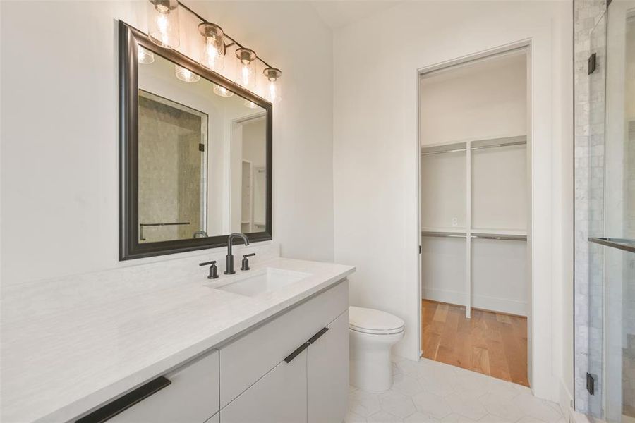 Another secondary bath showing the walk-in shower and closet.