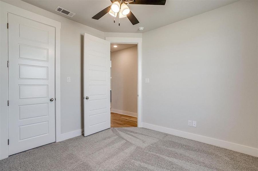 Unfurnished bedroom featuring light colored carpet and ceiling fan