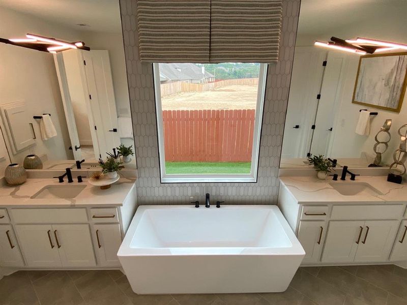 Stand-alone tub with tile to ceiling and large window