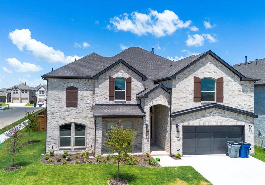 French country style house with a garage and a front lawn