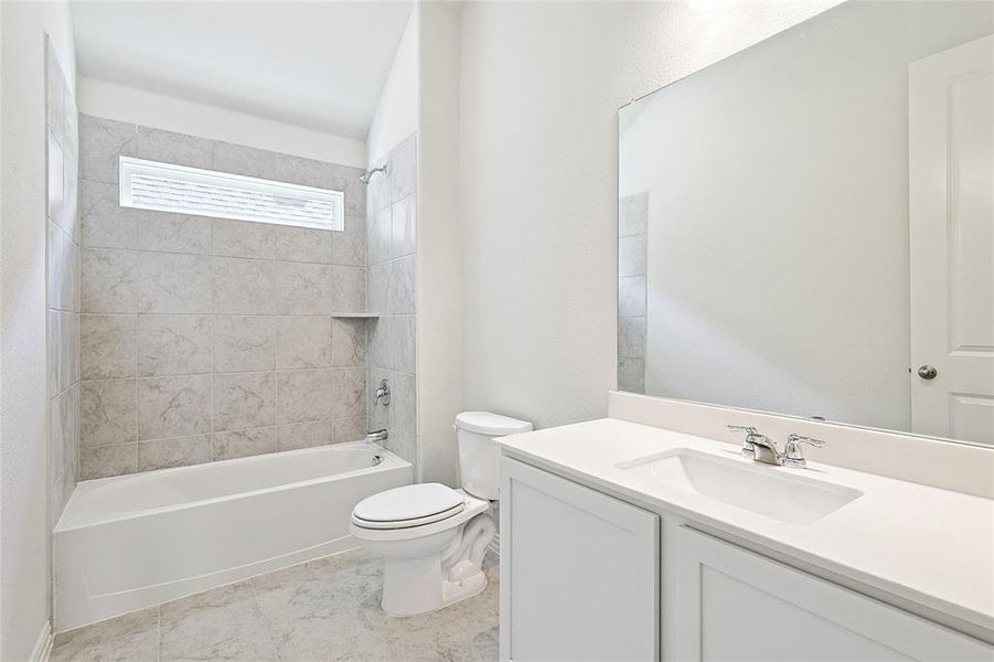 Full bathroom with vanity, toilet, and tiled shower / bath combo