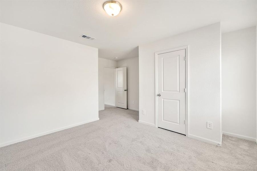 Unfurnished bedroom with light carpet